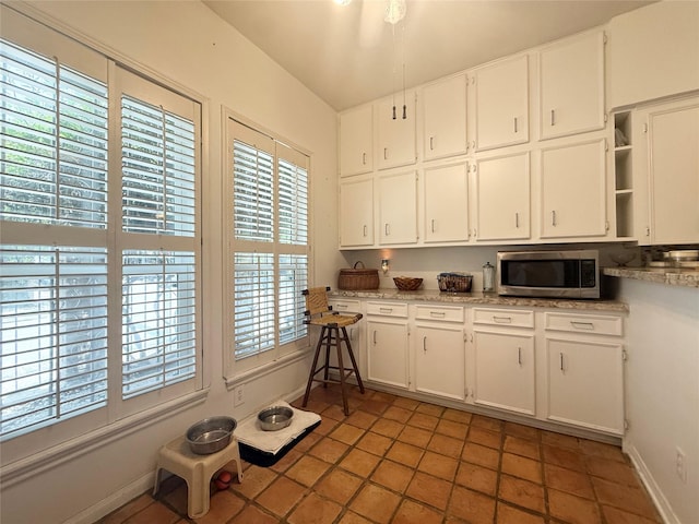 4703 Yoakum Blvd, Houston, TX 77006 - kitchen with stainless steel microwave, open shelves, healthy amount of natural light, and white cabinets