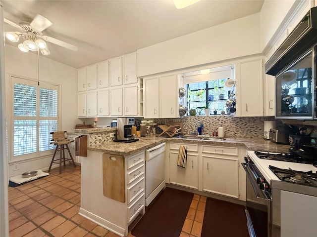 4703 Yoakum Blvd, Houston, TX 77006 - kitchen featuring white appliances, dark tile patterned floors, a ceiling fan, tasteful backsplash, and white cabinets