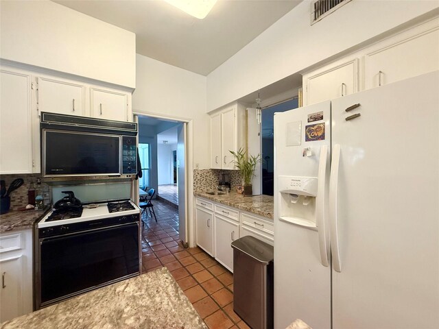 4703 Yoakum Blvd, Houston, TX 77006 - kitchen with white appliances, decorative backsplash, tile patterned flooring, and white cabinetry