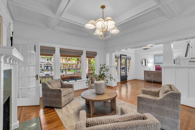 501 Avondale St, Houston, TX 77006 - living area featuring a chandelier, coffered ceiling, crown molding, wood finished floors, and beamed ceiling