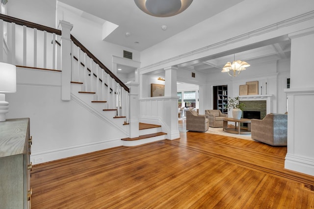 501 Avondale St, Houston, TX 77006 - living area featuring wood-type flooring, stairway, beam ceiling, coffered ceiling, and a chandelier