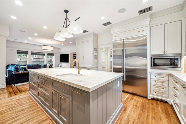 501 Avondale St, Houston, TX 77006 - kitchen with built in appliances, a sink, open floor plan, white cabinetry, and recessed lighting