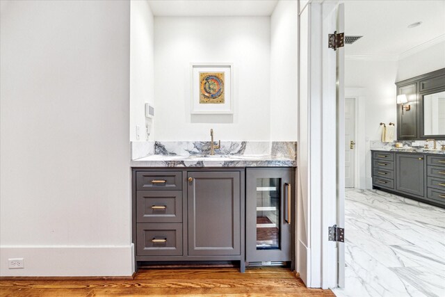 501 Avondale St, Houston, TX 77006 - indoor wet bar with wine cooler, crown molding, and light marble finish floors