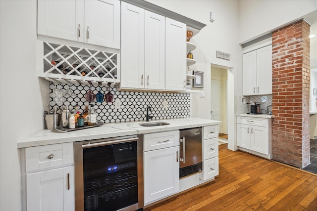1128 W Temple St, Houston, TX 77009 - kitchen featuring wine cooler, a sink, backsplash, light wood-style floors, and open shelves