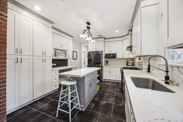 1128 W Temple St, Houston, TX 77009 - kitchen featuring appliances with stainless steel finishes, a sink, a center island, light stone counters, and tasteful backsplash