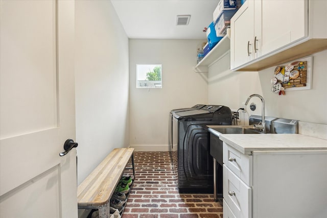 1128 W Temple St, Houston, TX 77009 - laundry room with brick flooring, cabinet space, separate washer and dryer, and baseboards