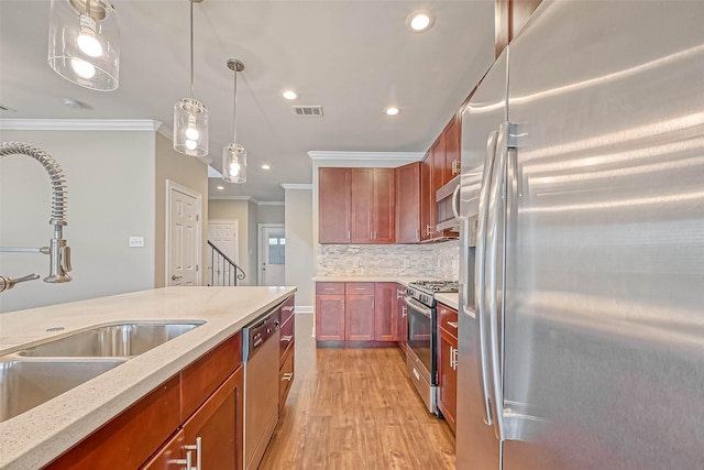 503 E 40th 1/2 St Unit A, Houston, TX 77022 - kitchen with appliances with stainless steel finishes, crown molding, a sink, light wood-type flooring, and decorative light fixtures