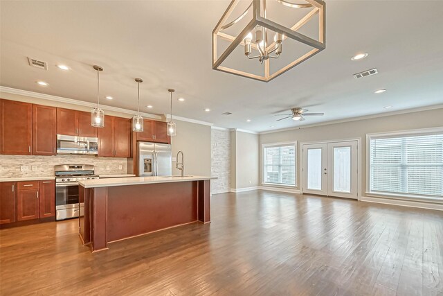 503 E 40th 1/2 St Unit A, Houston, TX 77022 - kitchen featuring stainless steel appliances, crown molding, open floor plan, light countertops, and an island with sink