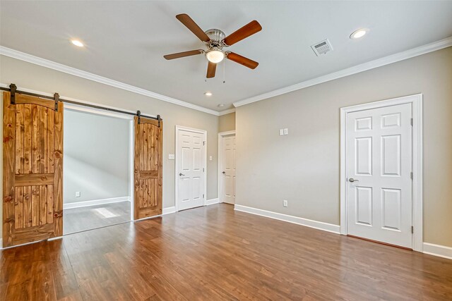 503 E 40th 1/2 St Unit A, Houston, TX 77022 - unfurnished bedroom featuring a barn door, recessed lighting, wood finished floors, crown molding, and baseboards