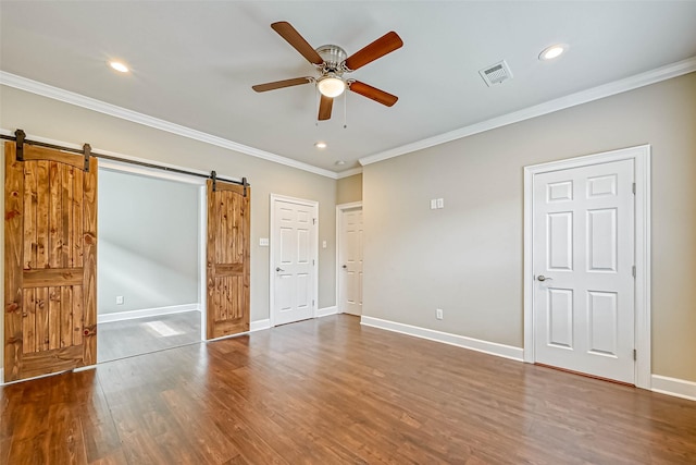 503 E 40th 1/2 St Unit A, Houston, TX 77022 - unfurnished bedroom featuring a barn door, recessed lighting, wood finished floors, crown molding, and baseboards