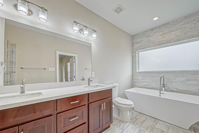 503 E 40th 1/2 St Unit A, Houston, TX 77022 - full bath featuring a freestanding tub, double vanity, toilet, a stall shower, and marble finish flooring