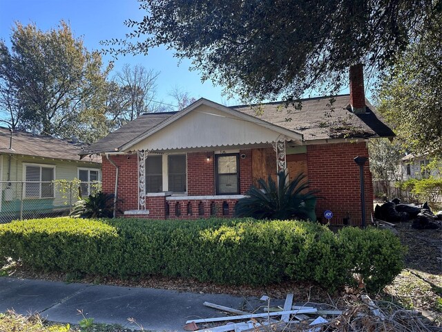 3016 Gray St, Houston, TX 77004 - view of front facade with brick siding, a chimney, and a porch