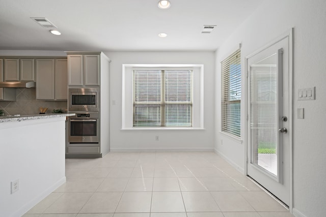 18719 Big Elm Dr, Cypress, TX 77433 - kitchen featuring appliances with stainless steel finishes, gray cabinetry, decorative backsplash, under cabinet range hood, and recessed lighting