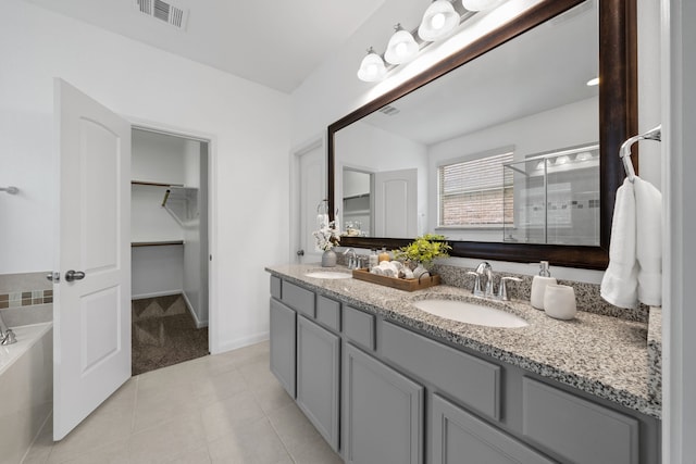 18719 Big Elm Dr, Cypress, TX 77433 - bathroom with double vanity, a shower stall, a spacious closet, a garden tub, and tile patterned flooring