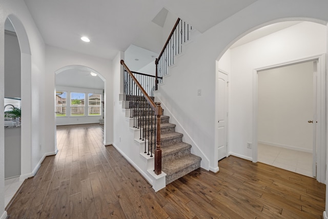 18719 Big Elm Dr, Cypress, TX 77433 - stairs featuring hardwood / wood-style flooring, baseboards, recessed lighting, and arched walkways