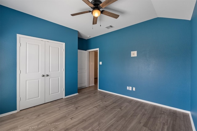 323 Jewett Meadow Dr, Magnolia, TX 77354 - unfurnished bedroom featuring wood finished floors, a closet, baseboards, a ceiling fan, and lofted ceiling