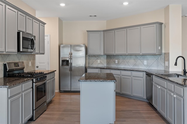 323 Jewett Meadow Dr, Magnolia, TX 77354 - kitchen with stainless steel appliances, a sink, gray cabinets, dark stone counters, and recessed lighting