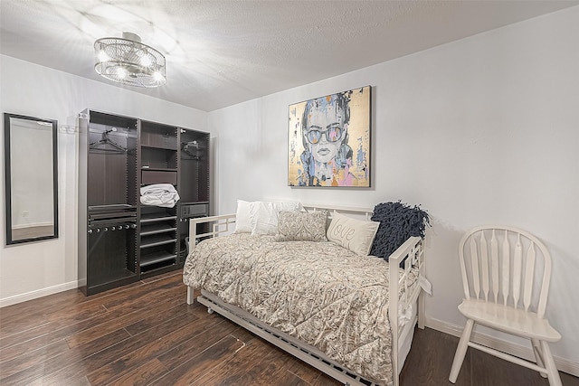 3131 Cummins St Unit 11, Houston, TX 77027 - bedroom with wood finished floors, baseboards, and a chandelier