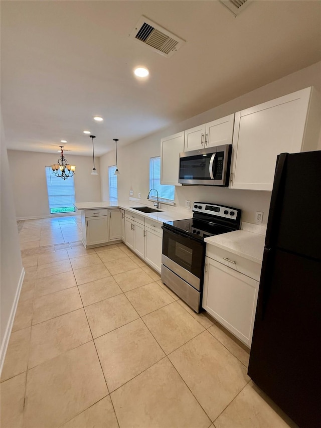 7318 Thurow St, Houston, TX 77087 - kitchen with appliances with stainless steel finishes, a sink, a chandelier, a peninsula, and light countertops