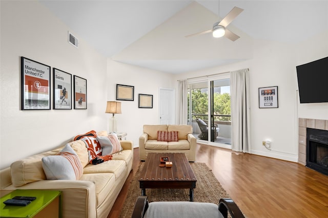 5200 Weslayan St Unit 309, Houston, TX 77005 - living room featuring a tile fireplace, wood finished floors, a ceiling fan, baseboards, and high vaulted ceiling