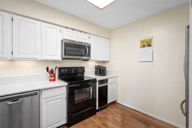 5200 Weslayan St Unit 309, Houston, TX 77005 - kitchen with appliances with stainless steel finishes, light wood-type flooring, light countertops, white cabinetry, and baseboards