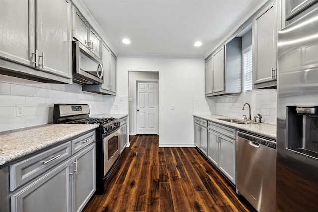 908 Kelley St, Houston, TX 77009 - kitchen with stainless steel appliances, a sink, gray cabinetry, tasteful backsplash, and dark wood-style flooring