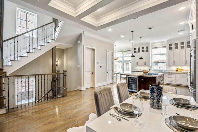 5420 Mcculloch Cir, Houston, TX 77056 - dining space with crown molding, beverage cooler, light wood-type flooring, baseboards, and recessed lighting