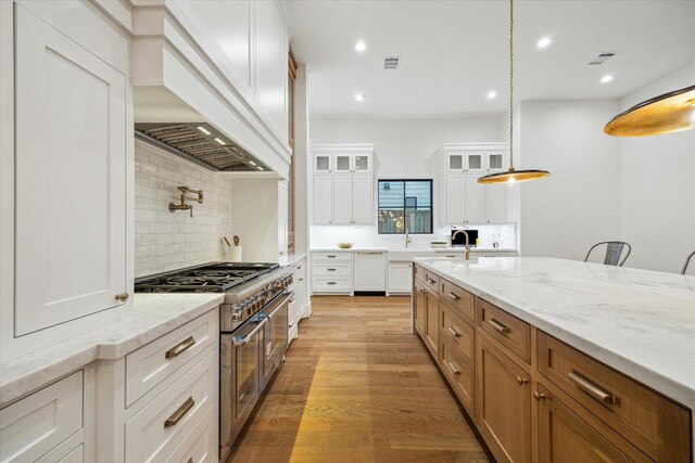 1314 Richelieu Ln, Houston, TX 77018 - kitchen with range with two ovens, glass insert cabinets, light stone counters, backsplash, and recessed lighting