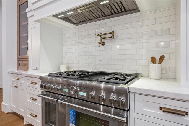 1314 Richelieu Ln, Houston, TX 77018 - kitchen featuring high end stainless steel range oven, premium range hood, tasteful backsplash, white cabinets, and light stone countertops