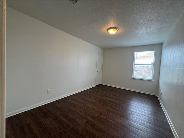 914 Paradise Rd, Baytown, TX 77521 - spare room featuring dark wood-style floors, baseboards, and a textured ceiling