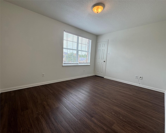 914 Paradise Rd, Baytown, TX 77521 - spare room with dark wood-style flooring, baseboards, and a textured ceiling