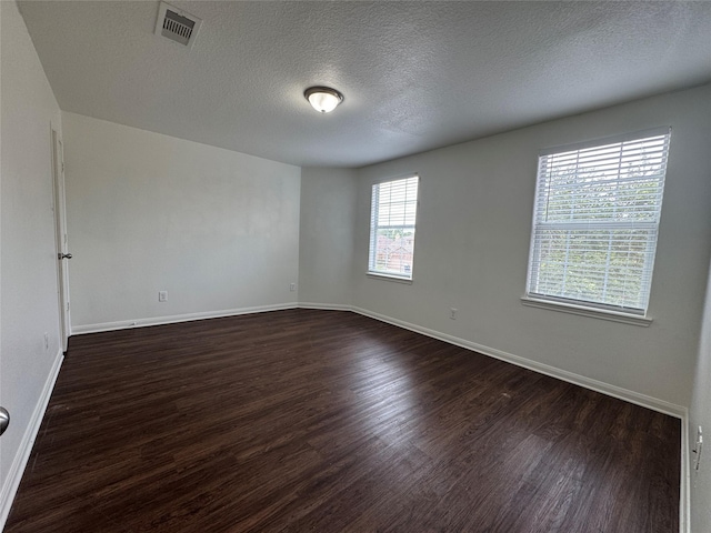 914 Paradise Rd, Baytown, TX 77521 - empty room with dark wood finished floors, baseboards, and a textured ceiling