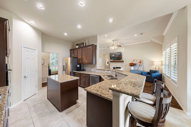 813 Woodland Ct, Conroe, TX 77302 - kitchen featuring stainless steel appliances, a sink, lofted ceiling, a kitchen island, and open floor plan