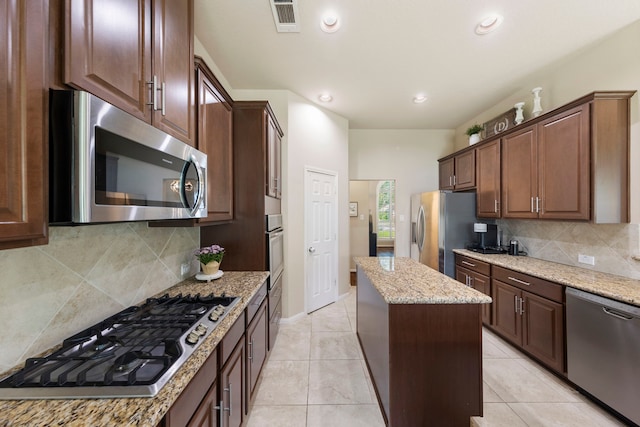 813 Woodland Ct, Conroe, TX 77302 - kitchen with stainless steel appliances, a kitchen island, light stone countertops, tasteful backsplash, and light tile patterned floors