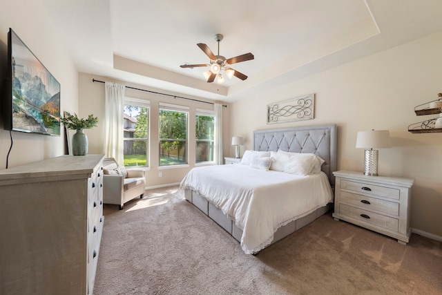 813 Woodland Ct, Conroe, TX 77302 - carpeted bedroom featuring a tray ceiling, baseboards, and ceiling fan