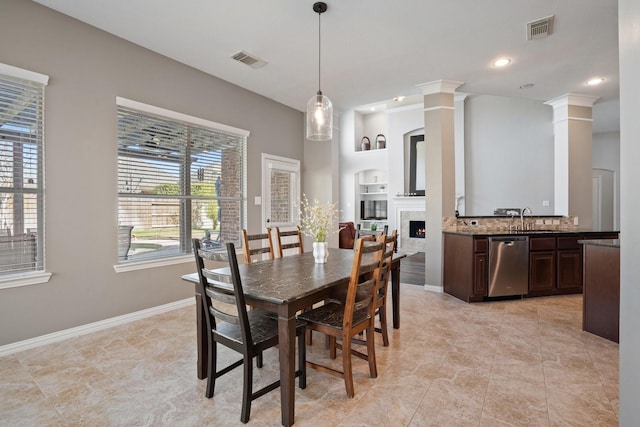 18430 S Settlers Shore Dr, Cypress, TX 77433 - dining space featuring decorative columns, a lit fireplace, recessed lighting, baseboards, and light tile patterned floors