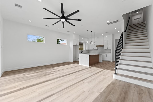 503 Nimrod St, Houston, TX 77020 - unfurnished living room with recessed lighting, a ceiling fan, stairs, light wood-style flooring, and baseboards