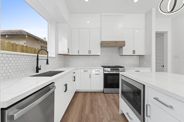 503 Nimrod St, Houston, TX 77020 - kitchen with appliances with stainless steel finishes, a sink, custom exhaust hood, light stone countertops, and white cabinetry