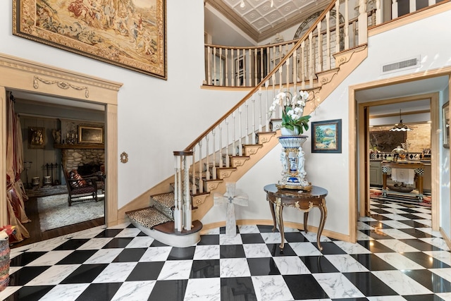 1561 Kirby Dr, Houston, TX 77019 - staircase with a high ceiling, baseboards, crown molding, and a fireplace