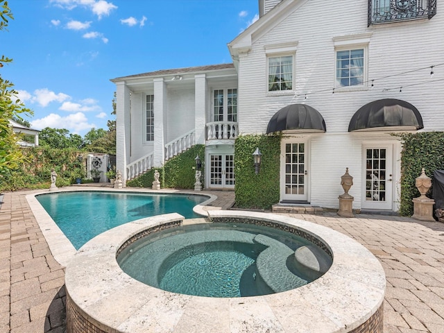 1561 Kirby Dr, Houston, TX 77019 - view of pool with french doors, a pool with connected hot tub, and a patio