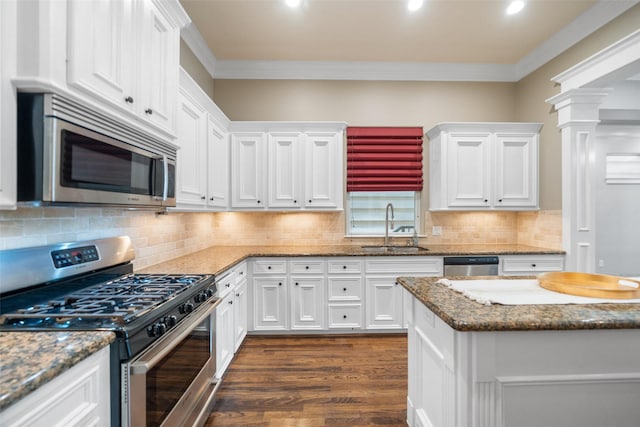 1332 W 25th St Unit A, Houston, TX 77008 - kitchen with stainless steel appliances, a sink, white cabinetry, ornamental molding, and dark wood-type flooring