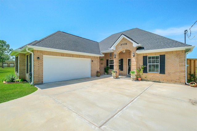 9206 Gene St, Needville, TX 77461 - view of front of home with a shingled roof, brick siding, driveway, and a garage