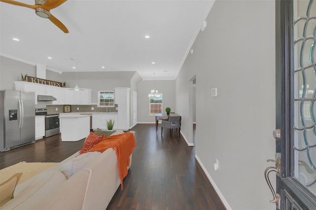 9206 Gene St, Needville, TX 77461 - living room featuring dark wood-type flooring, ornamental molding, ceiling fan, recessed lighting, and a chandelier