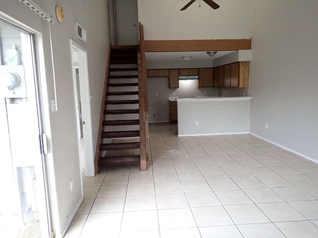 6383 Dryad Dr Unit 638, Houston, TX 77035 - unfurnished living room featuring ceiling fan, stairway, light tile patterned flooring, and baseboards