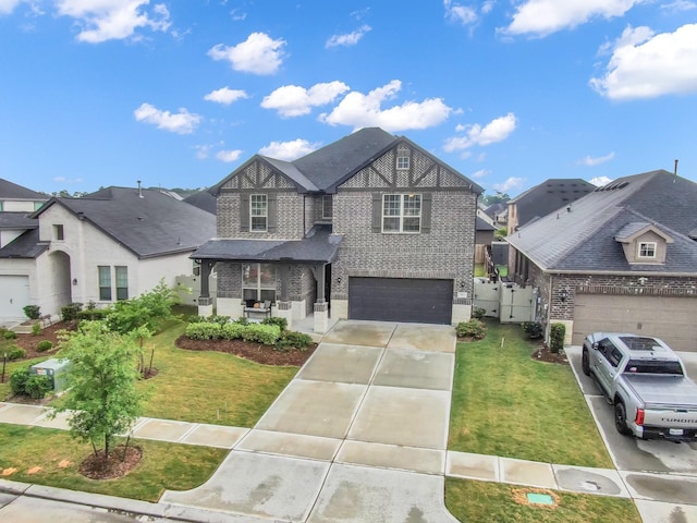 17413 Turtleweed Ln, Conroe, TX 77385 - tudor house featuring brick siding, concrete driveway, a garage, and a residential view