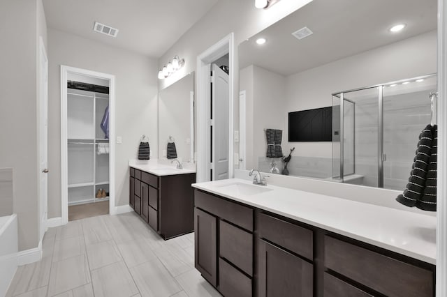 17413 Turtleweed Ln, Conroe, TX 77385 - full bath featuring a stall shower, a walk in closet, two vanities, and baseboards