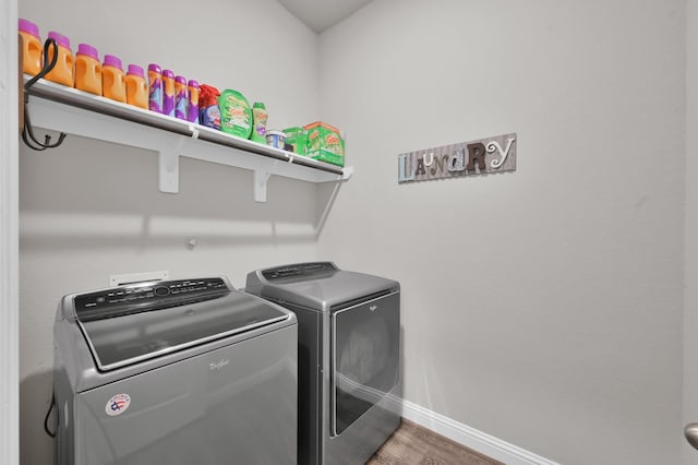 17413 Turtleweed Ln, Conroe, TX 77385 - laundry room with washing machine and clothes dryer, baseboards, and wood finished floors