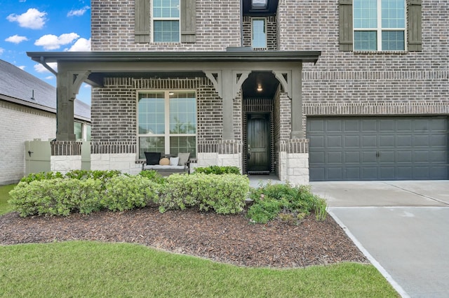 17413 Turtleweed Ln, Conroe, TX 77385 - view of exterior entry with brick siding, a garage, and concrete driveway
