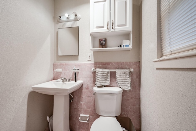 204 Carnation St, Lake Jackson, TX 77566 - half bath featuring toilet, tile walls, a wainscoted wall, and a sink