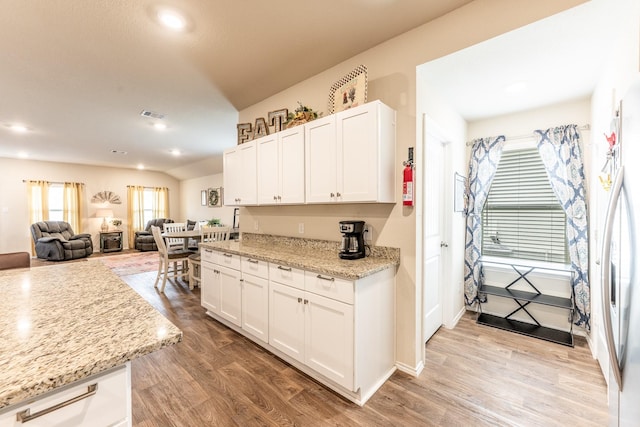 128 Barton Creek Dr, Huntsville, TX 77340 - kitchen featuring light wood-type flooring, white cabinetry, open floor plan, light stone countertops, and recessed lighting